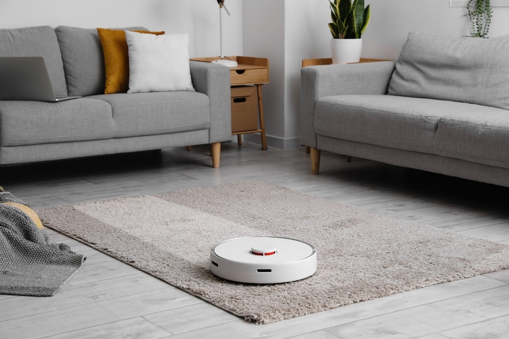 Modern robot vacuum cleaner on soft carpet in room