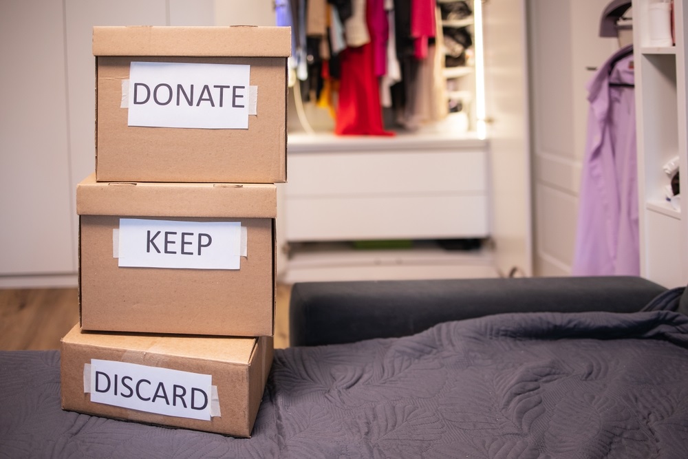 sorting clothes into three boxes that stand on top of each other