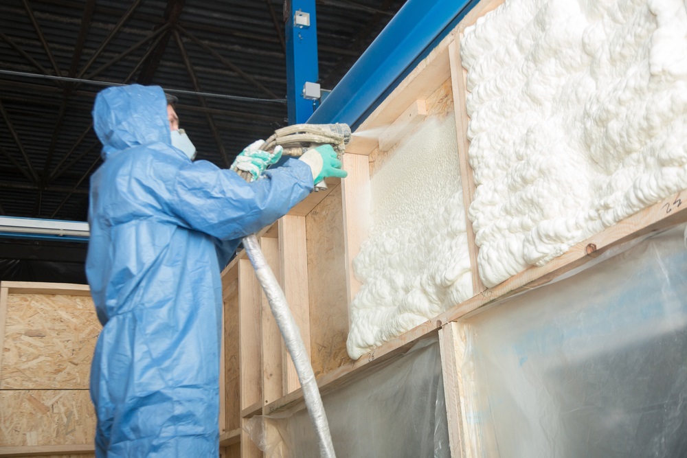 worker insulates the walls of the house with foam for sound insulation and heat