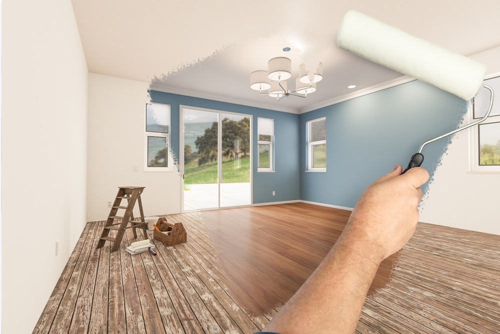 Before and After of Man Painting Roller to Reveal Newly Remodeled Room with Fresh Blue Paint and New Floors