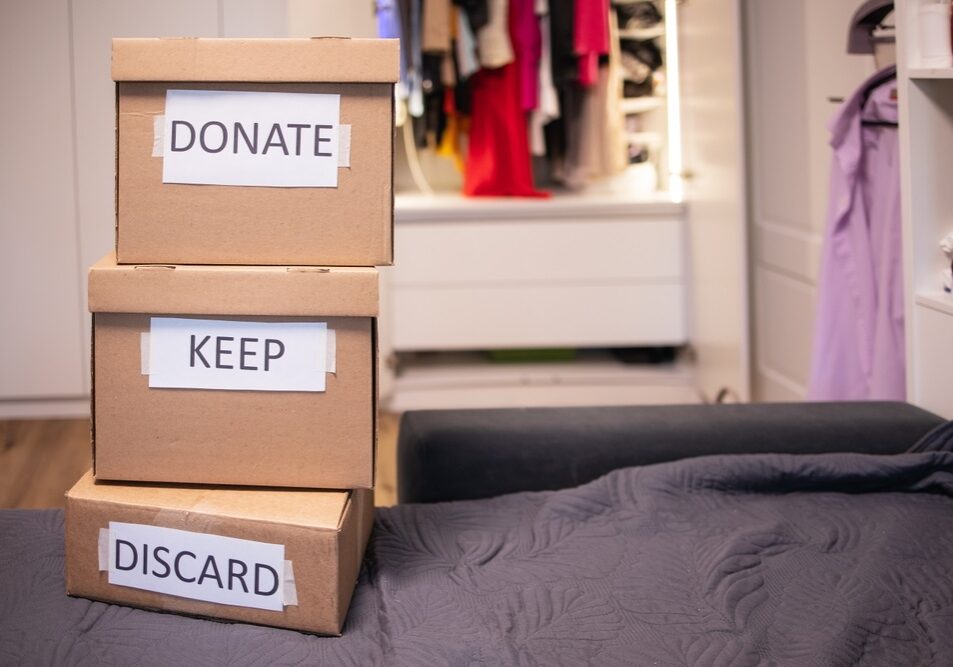 sorting clothes into three boxes that stand on top of each other sorting clothes into three boxes that stand on top of each other