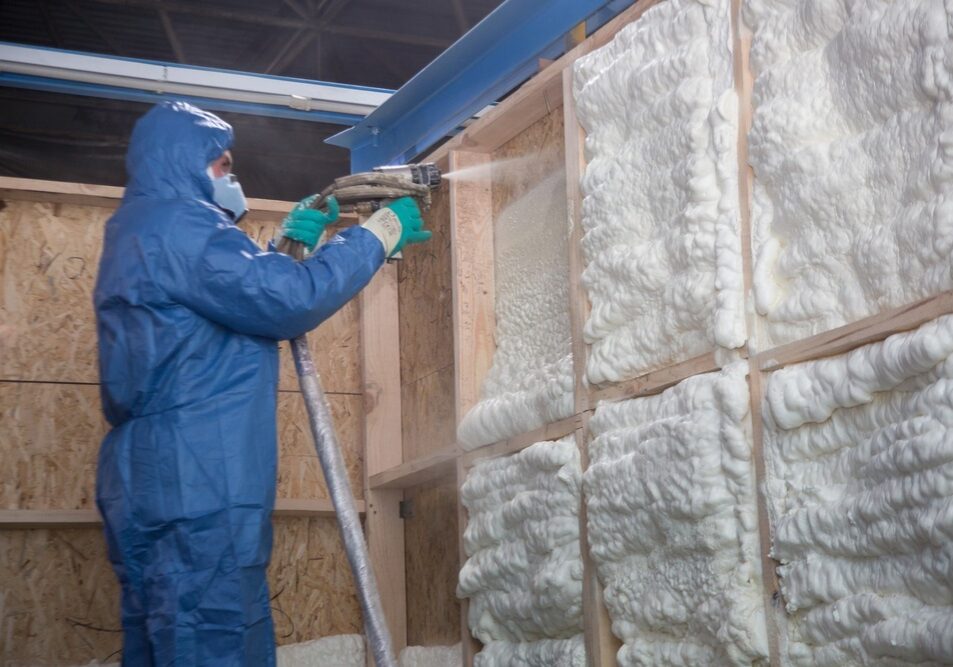 The worker insulates the walls of the house with foam for sound insulation and heat The worker insulates the walls of the house with foam for sound insulation and heat