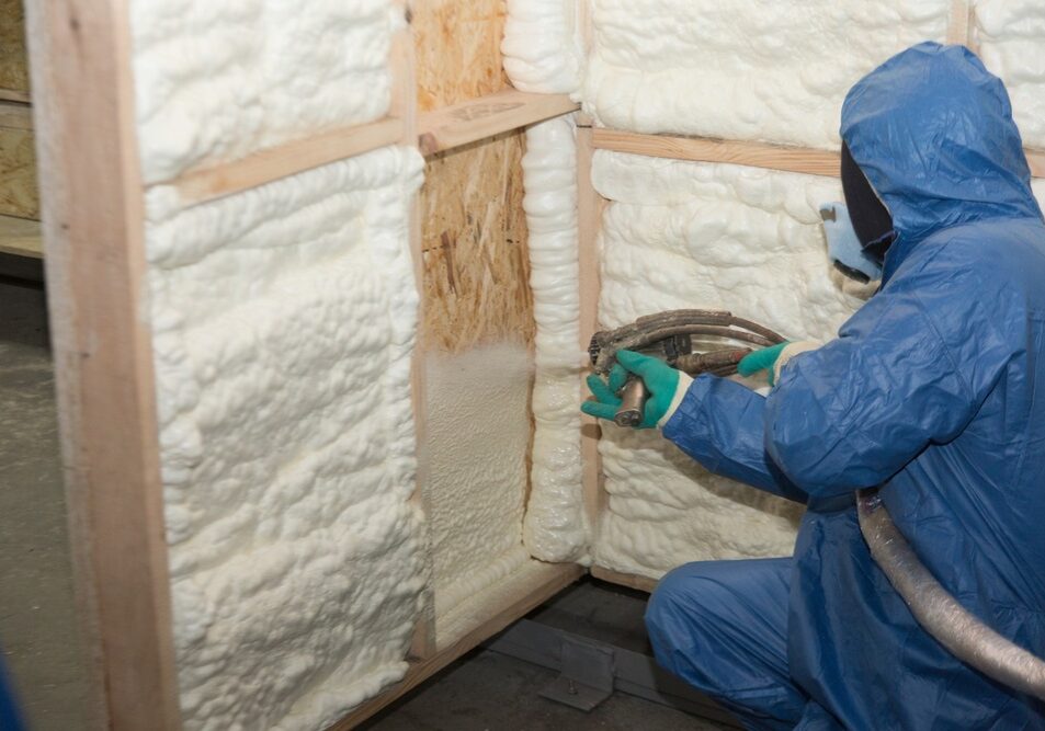 builder in a blue suit applies a construction foam builder in a blue suit applies a construction foam