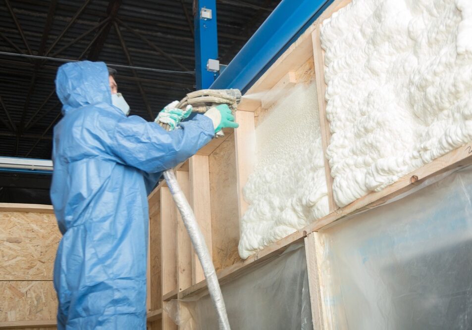 worker insulates the walls of the house with foam for sound insulation and heat
