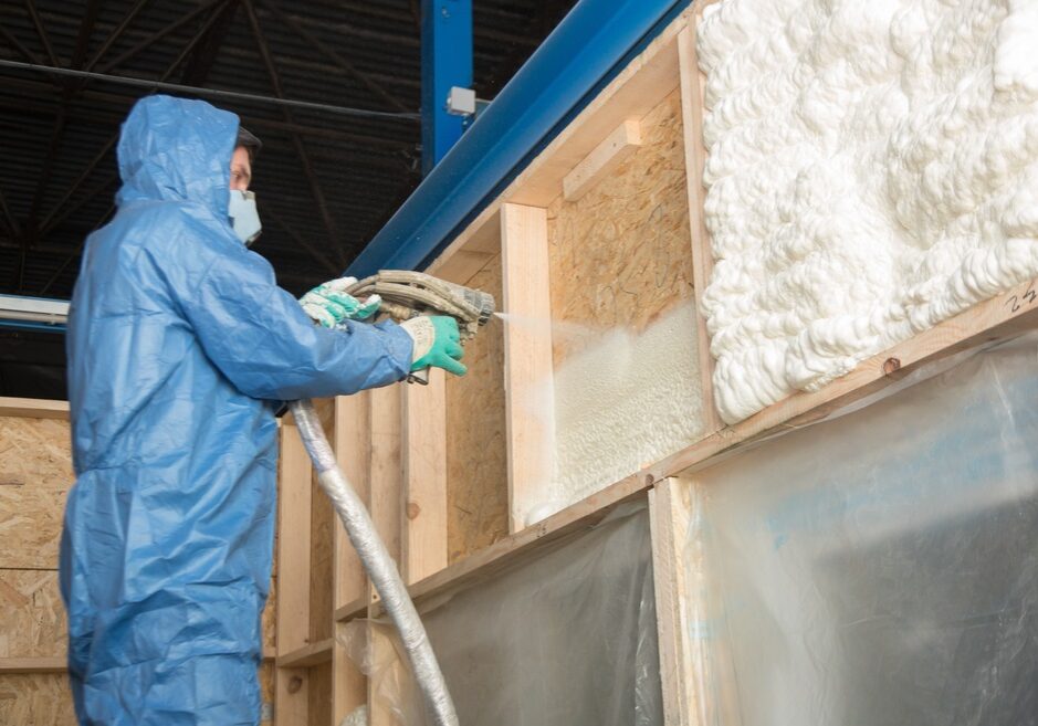 The worker insulates the walls of the building with foam for sound insulation and heat The worker insulates the walls of the building with foam for sound insulation and heat