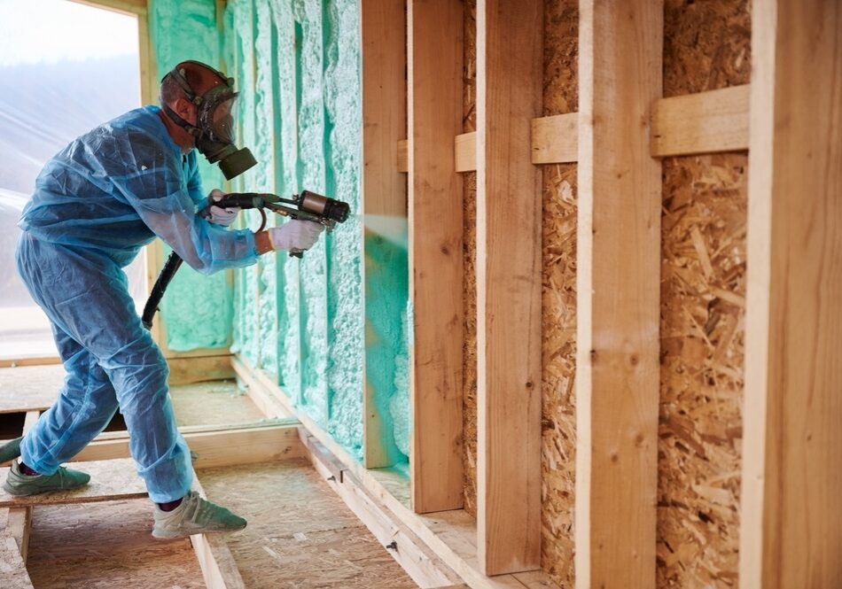 Male builder insulating wooden frame hous Male builder insulating wooden frame hous
