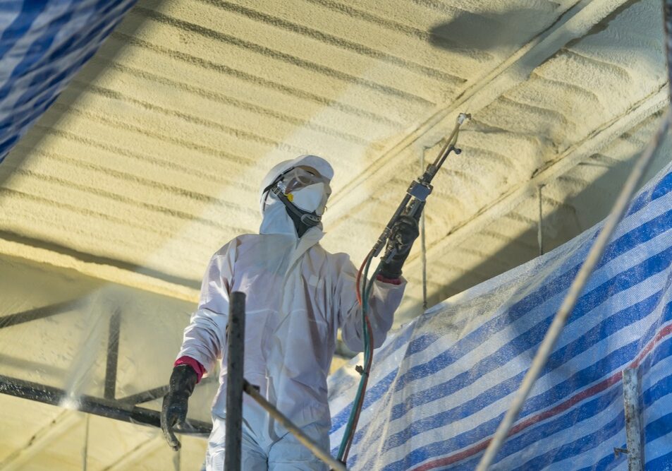 Technician spraying foam insulation using Plural Component Gun for polyurethane foam Technician spraying foam insulation using Plural Component Gun for polyurethane foam