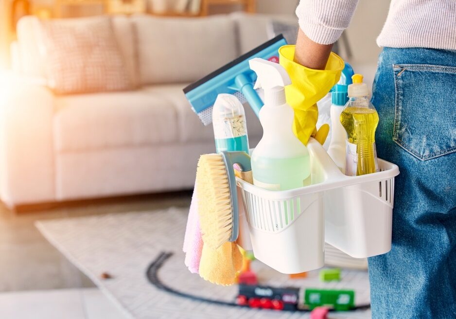Cleaning, hand and basket of cleaning supplies for family home hygiene with a brush, bottles and gloves Cleaning, hand and basket of cleaning supplies for family home hygiene with a brush, bottles and gloves