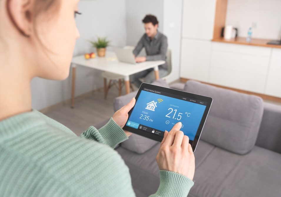 Woman using smart home application on table Woman using smart home application on table